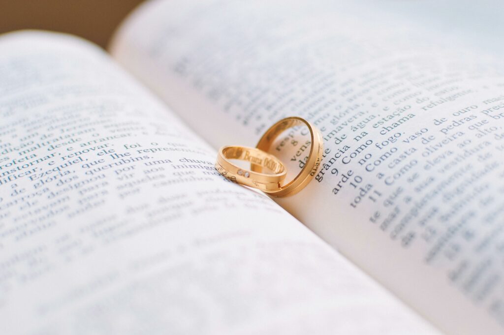 Wedding rings placed on a book about the Green Card process, symbolizing marriage-based immigration.