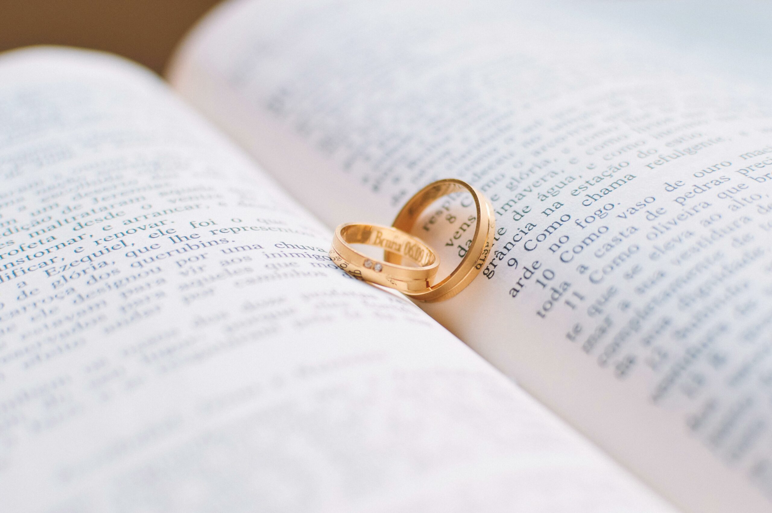 Wedding rings placed on a book about the Green Card process, symbolizing marriage-based immigration.