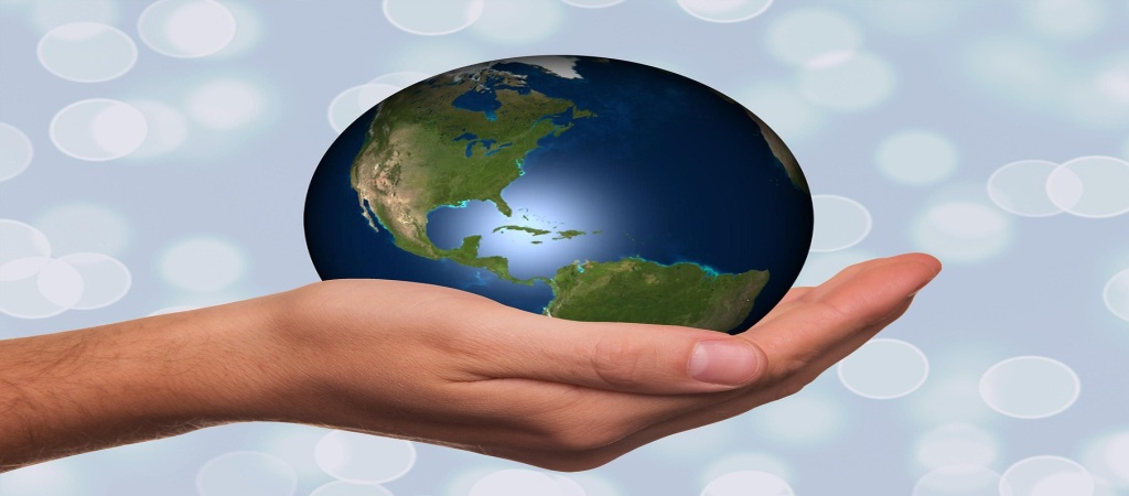 Una mano sosteniendo el mundo que simboliza la movilidad internacional y el cambio en las visas de trabajo de EE. UU. bajo el debate de Visa L1 vs H1B.