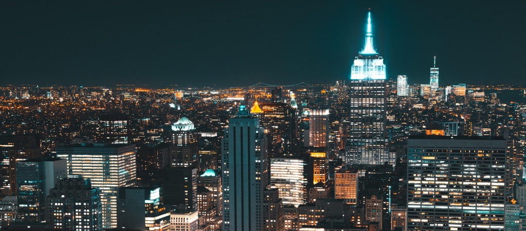 Vista nocturna del skyline de Nueva York que simboliza a los profesionales globales eligiendo entre la Visa L1 vs H1B para construir su futuro en EE. UU.