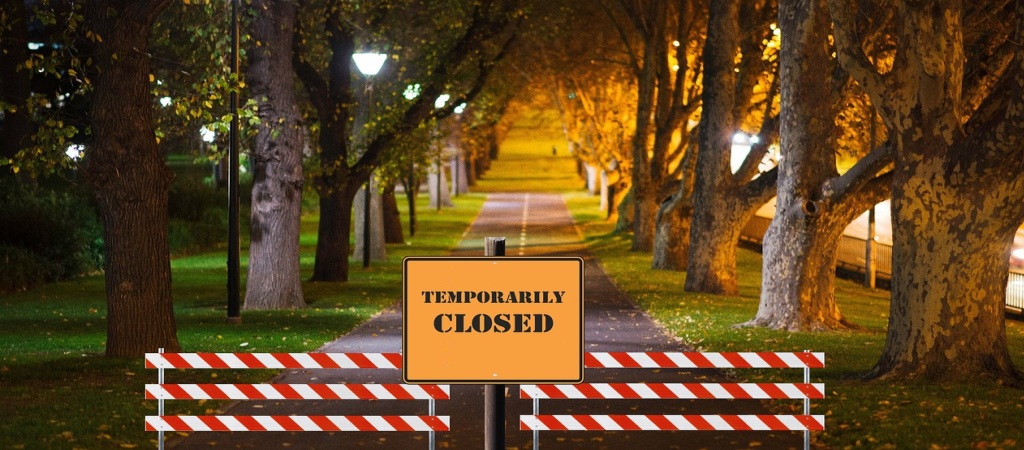 “Temporarily closed” yazılı tabela ve kapatma işaretleriyle kapatılmış park girişi, 2025 hükümet kapanışının etkilerini gösteriyor.